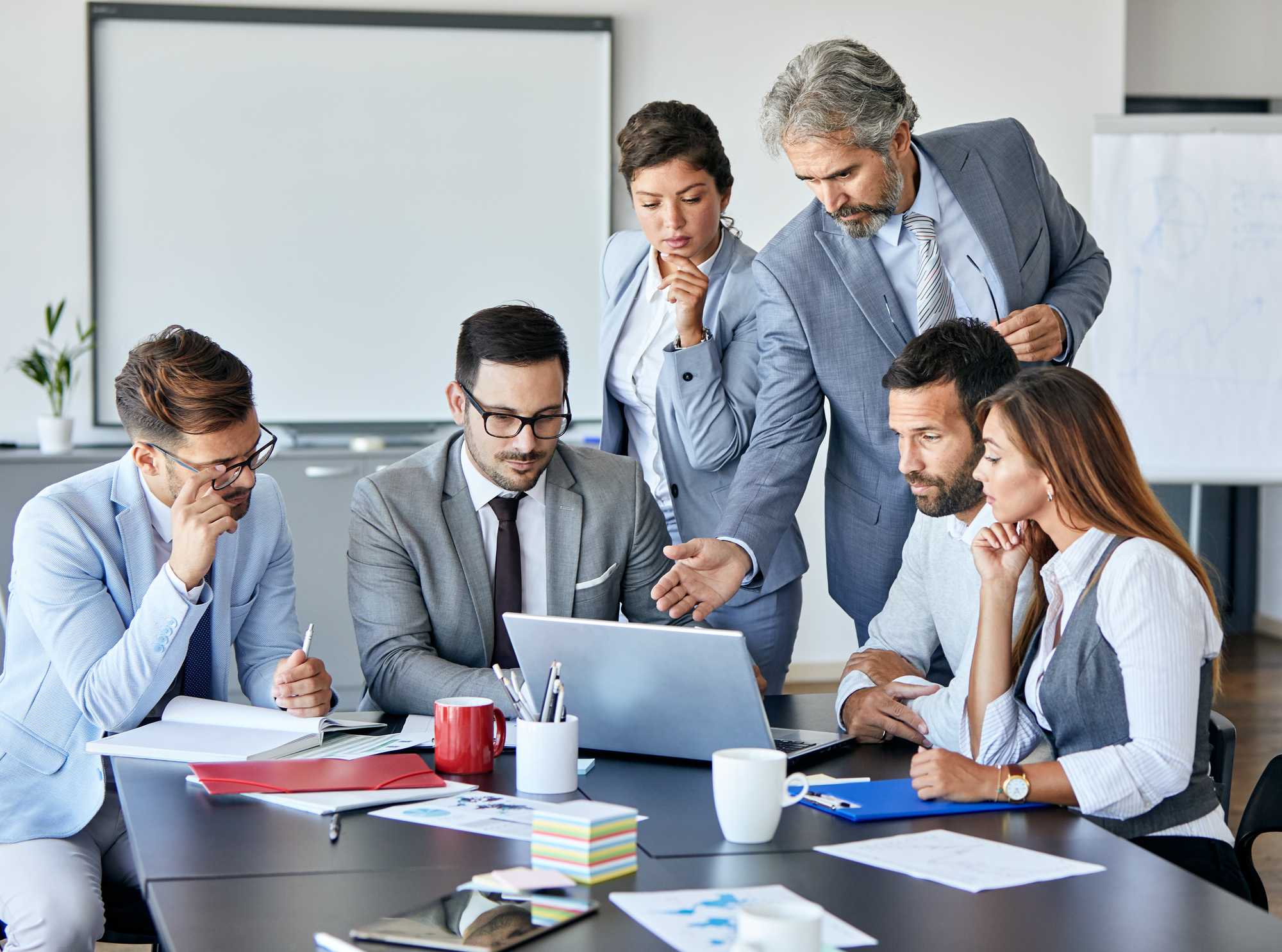 équipe regroupée autour de l'ordinateur portable, milieu de terrain, gris, blanc