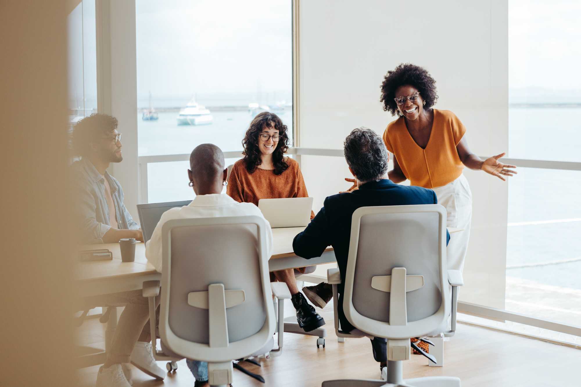 woman leading meeting, distance, orange, taupe