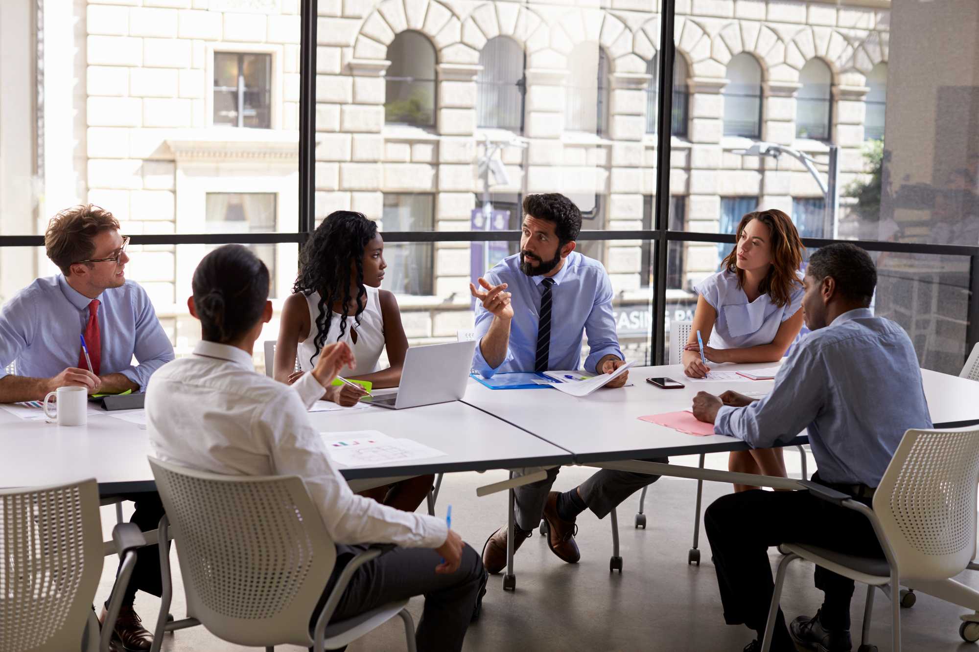 large team meeting at conference table, distance, dark